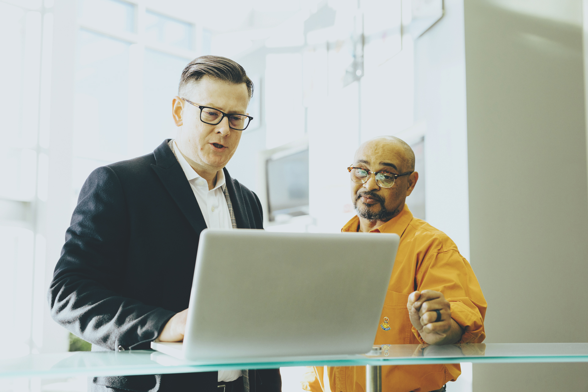 two business professionals looking at a laptop